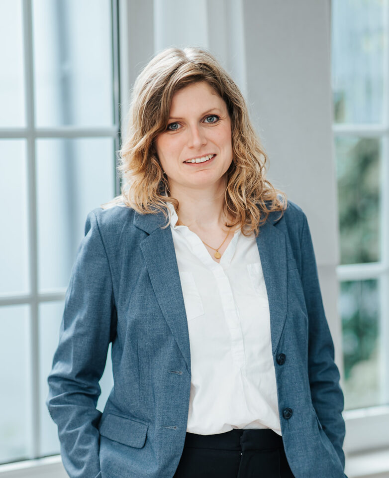 Porträtfoto von Philipp Volotas für die Teamseite von Heykes&Karstens, stehend und im Hintergrund ein Fenster